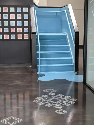 Bright blue staircase with artistic floor design at REWIRE ALCOHOL & DRUG Education detox center in Houston.