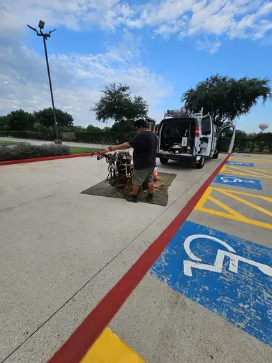 Man working on bicycles in parking lot at Abundance Living Inc, a sober living home in Houston.