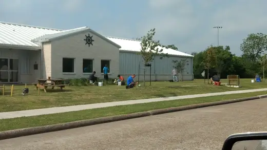 Landscaped front yard with people gardening at The Wheelhouse, a sober living home in Houston.